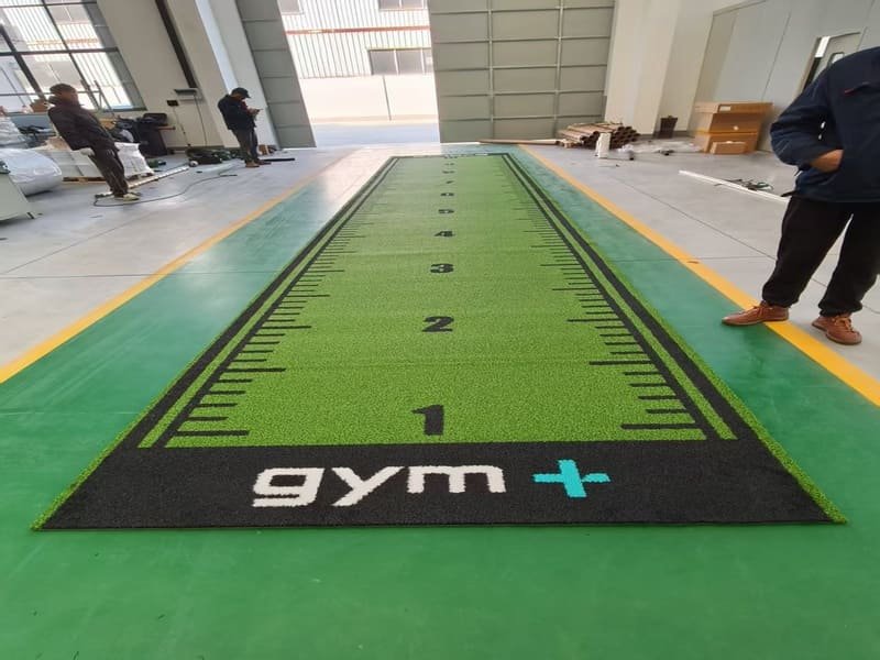man brushing gym turf track